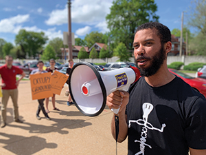 A student speaks to the crowd at a Fight for $15 rally on the WashU campus in St. Louis. Photo credit: WashU Graduate Workers Union, SEIU Local