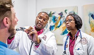 Dr. Anthony Speights, left, director of the Bridge to Clinical Medicine Master’s Program at the Florida State University College of Medicine, examines a patient along with 2019 alumna Dr. Martine Sainvilus.