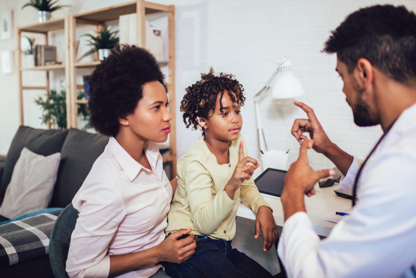 Photo of an African American man, woman, and child using sign language