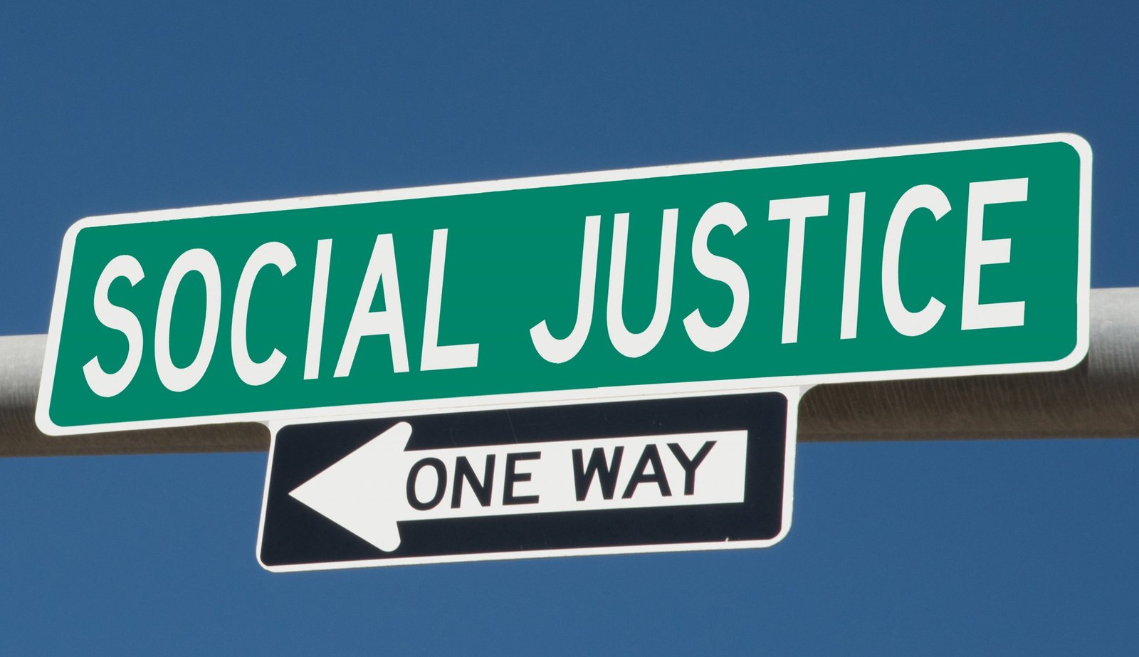 A sign that reads Social Justice above a sign with an arrow that says One Way