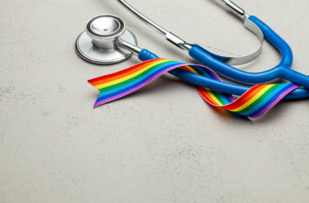 Photo of a rainbow LGBTQ pride flag wrapped around a stethoscope.