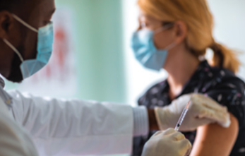 Photo of a medical professional administering a COVID-19 vaccine to a patient.