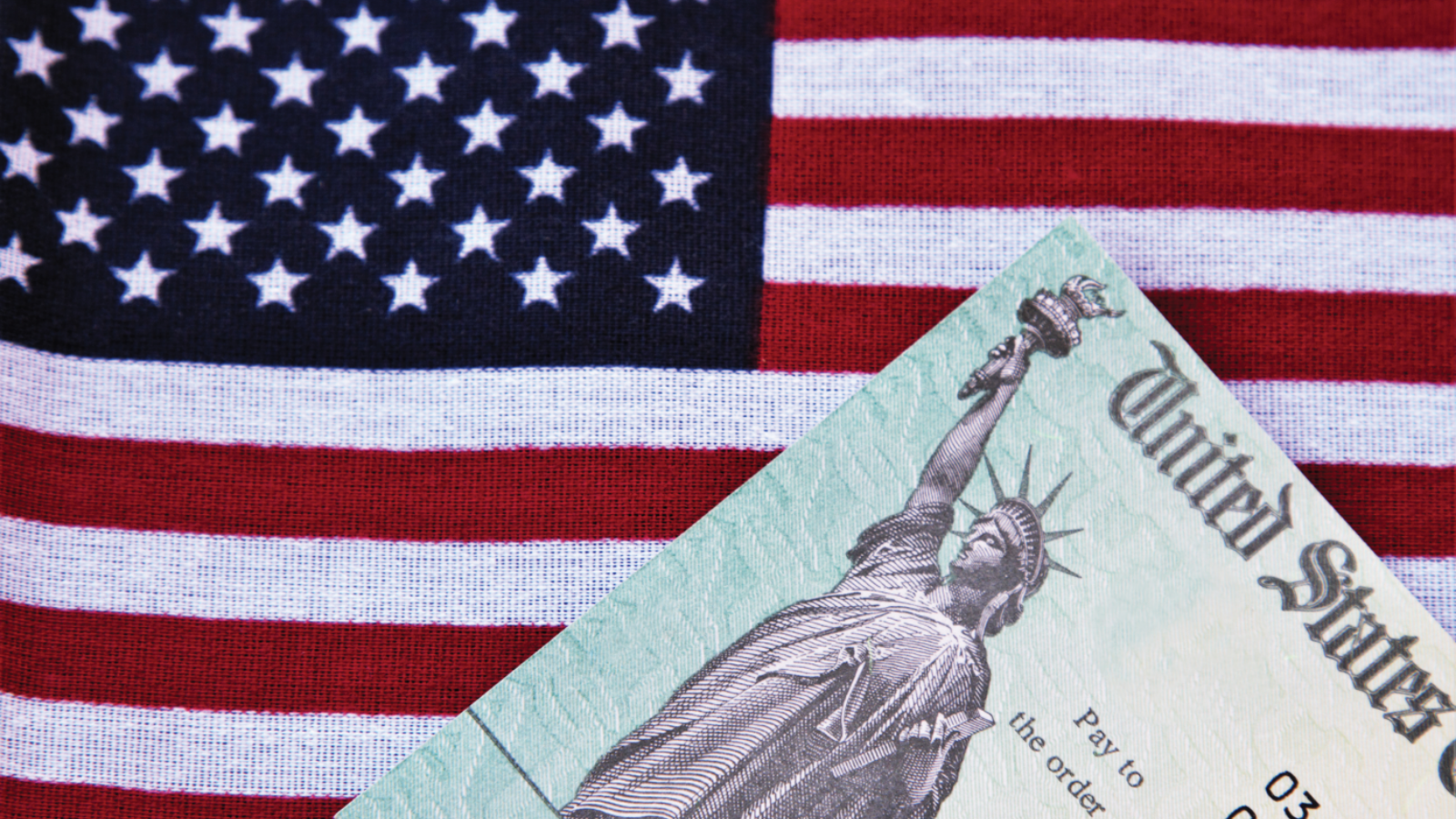 Photo of a check from the U.S. treasury lying on an American flag.