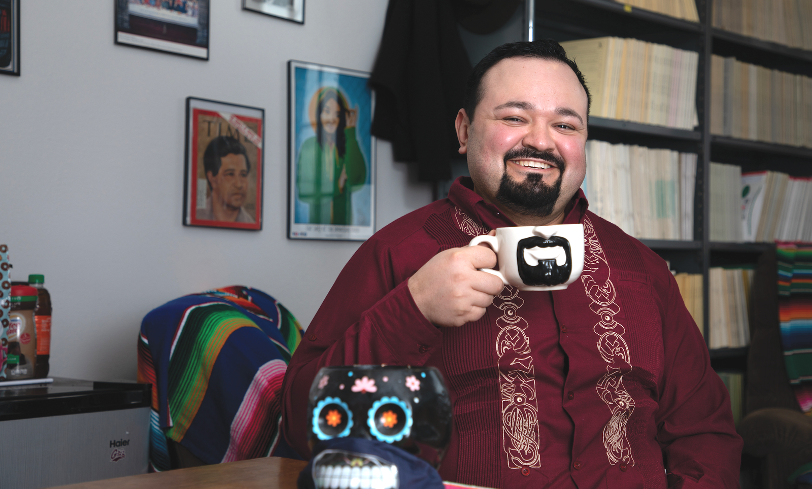 Professor Erim Gómez poses with his beard mug at UM. Items in the image signify his Mexican heritage, including his guayabera, or traditional Latin American shirt.