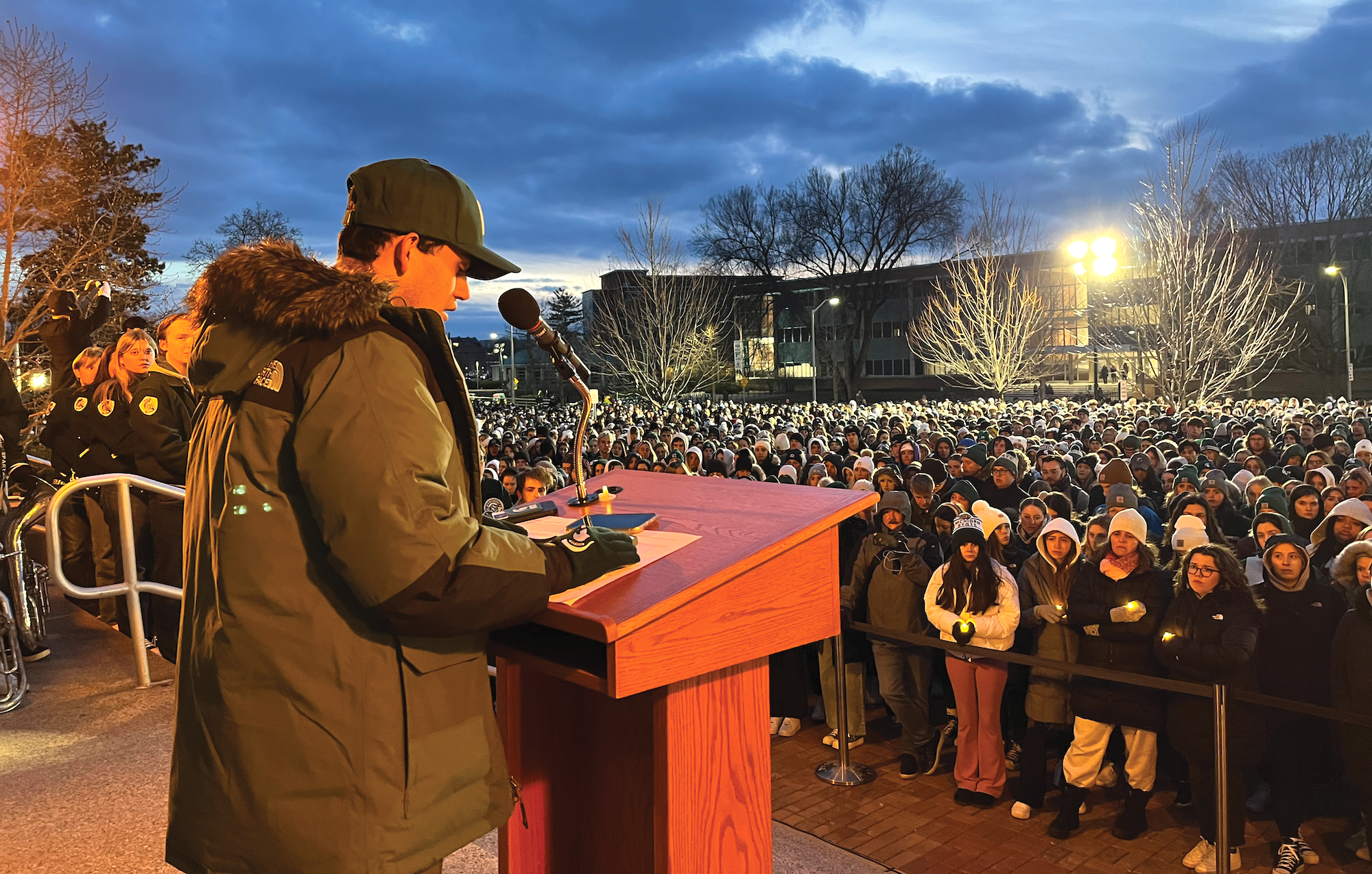 Michigan State University student Joseph Kesto stands at a podium in front of a crowd