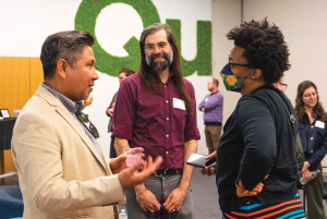 Dalmacio Dennis Flores, PhD, (left) assistant professor of nursing at the University of Pennsylvania and faculty expert with the Eidos LGBTQ+ Health Initiative, chats at an Eidos campus event in April 2023. (Photo courtesy of Eidos LGBTQ+ Health Initiative)
