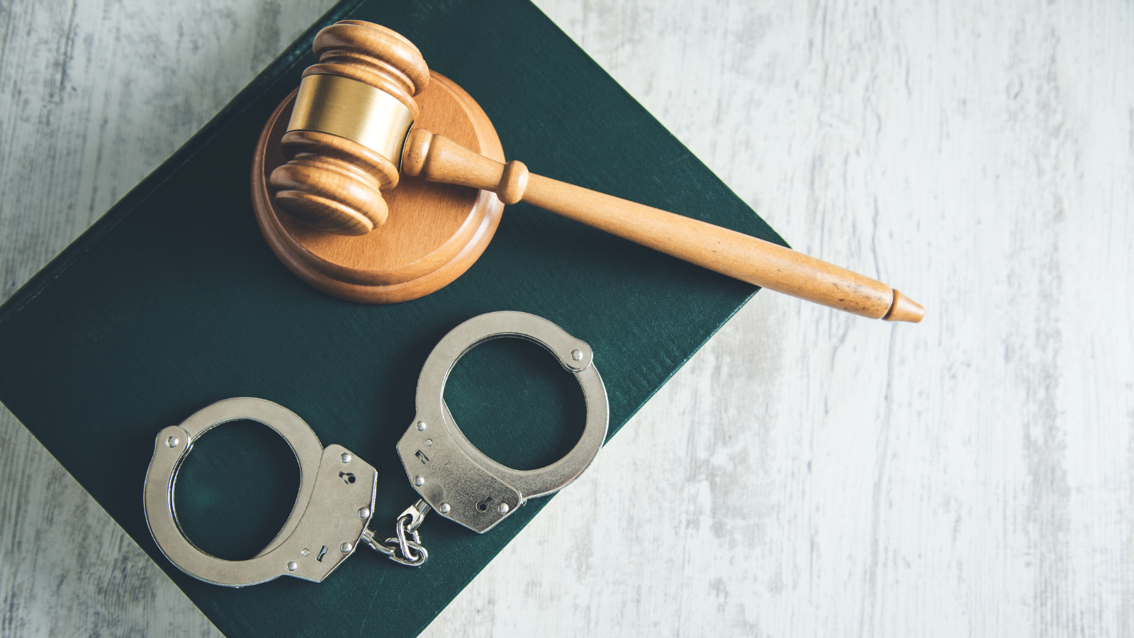 gavel and handcuffs on top of a book